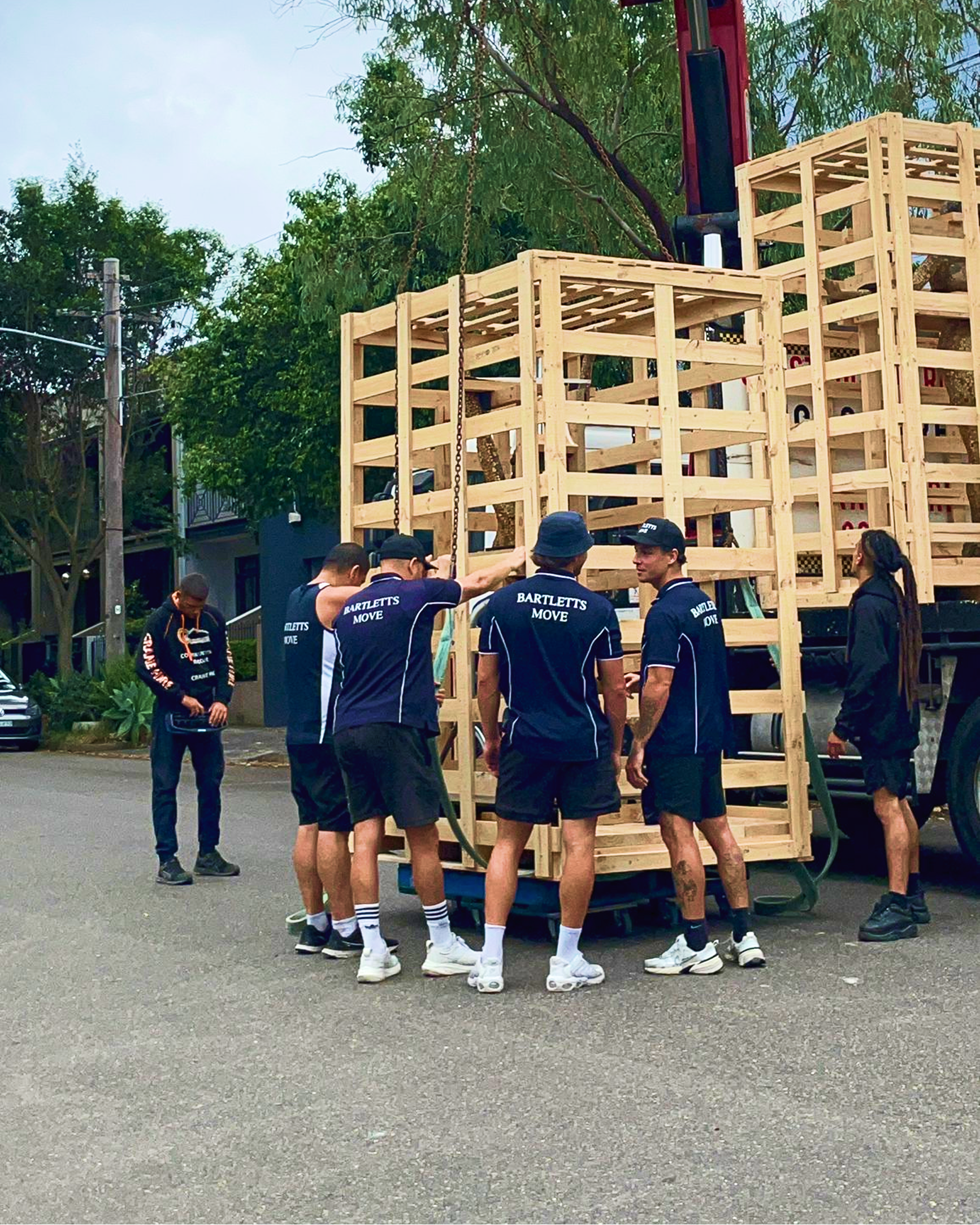 Bartletts Move crew loading a large wooden crate onto a crane truck